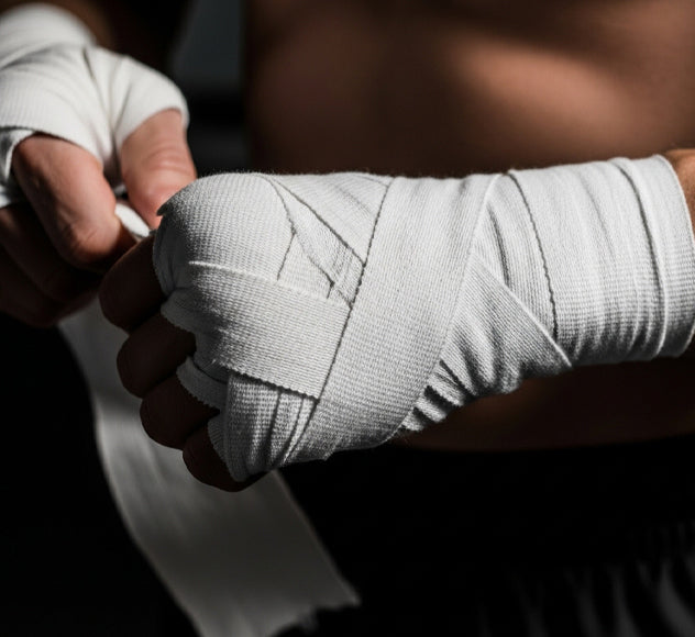 Boxer learning how to strengthen their wrists with hand wrap and wrist exercises before training