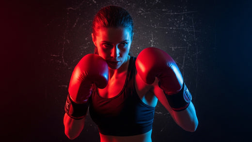 Female boxer standing in a gym comparing women’s boxing weight class chart